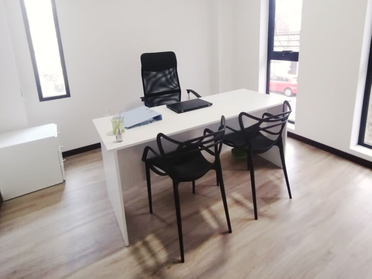 Oficina de Nexus en Rosario: escritorio de reunión con sillas para quienes consultan